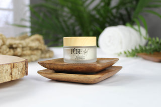 A small jar of face cream on wooden dishes