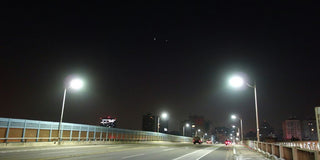 A street at night with street lights and street signs