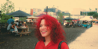 a woman with red hair standing in a park