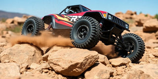 RC car climbing rocky terrain in an outdoor setting.