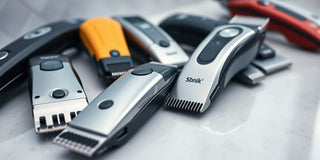 Close-up of assorted hair clippers on a countertop.