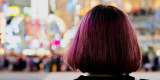 purple apple-cut haired woman facing at the back