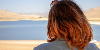 woman in gray shirt standing on beach during daytime