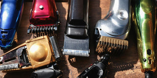 Various hair clippers on a wooden surface.