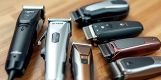 Various barbershop clippers on a wooden countertop.