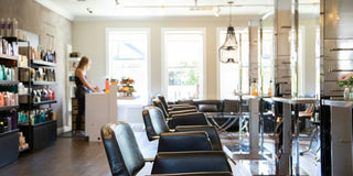 woman in white shirt standing near black leather chairs