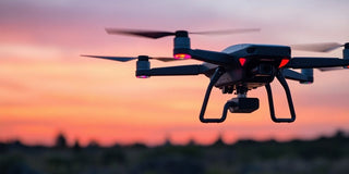 Drone with thermal camera flying over a twilight landscape.