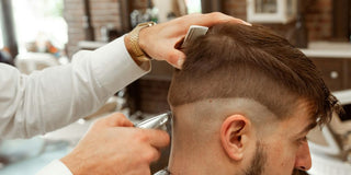 man in white dress shirt cutting hair of man